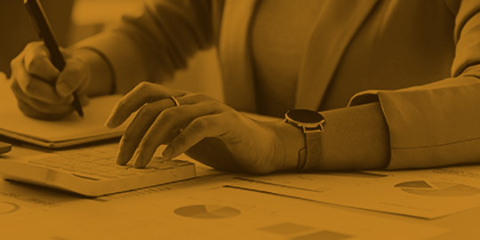 Accountant bookkeeper works on analyzing financial data using a calculator and writing notes with calculations. Accounting Concepts and Personal Financial Planning.